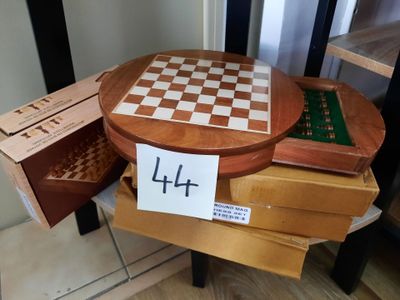 une table en bois sur laquelle se trouvent un échiquier et une boîte