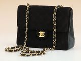 a close up of a black purse with a chain around it