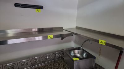 a stainless steel sink in the corner of a kitchen