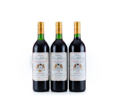 trois bouteilles de vin rouge posées l'une à côté de l'autre sur une surface blanche