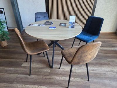 quatre chaises disposées autour d'une table ronde sur laquelle se trouve un magazine