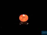 a close up of an orange stone on a black surface