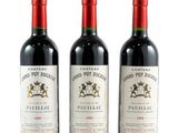trois bouteilles de vin rouge posées l'une à côté de l'autre sur une surface blanche