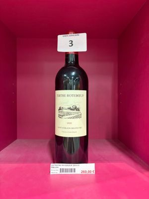 une bouteille de vin posée sur une étagère, dans une boîte rose
