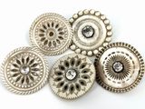 six boutons en argent ornés d'un diamant au centre, sur un fond blanc