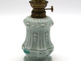 une petite lampe verte posée sur une table blanche