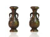 paire de vases anciens en bronze sur fond blanc avec reflet