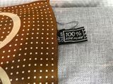 a brown and white polka dot tie with a tag on it