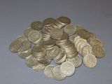 a pile of coins sitting on a table next to a pair of scissors