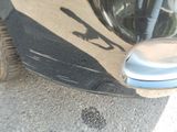 a close up of a car ' s front bumper with a reflection of a person on it