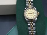 a rolex watch that is sitting on top of a wallet