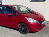 une petite voiture rouge garée devant un immeuble
