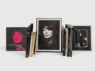 Trois livres sont empilés les uns sur les autres devant la photo d'une femme