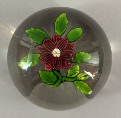 a glass ball with a flower on it on a table