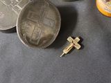 a small silver coin and a small cross on a table