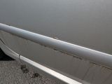 a white car with rust on the side of it ' s door