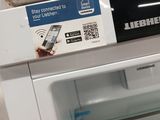a white refrigerator with the door open and a cell phone in it