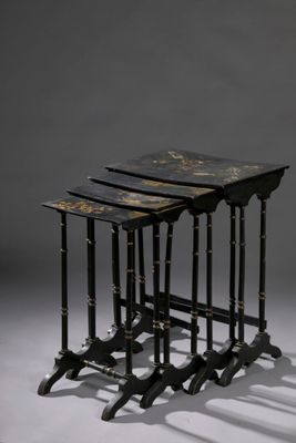 trois tables gigognes noires et dorées sur fond gris