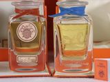two bottles of perfume sitting on top of a table next to a box