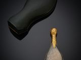 un gros plan d'une cuillère remplie de sucre à côté d'une paire de chaussures