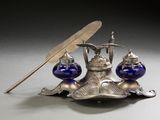 a silver plate with a pen and inkwell on it
