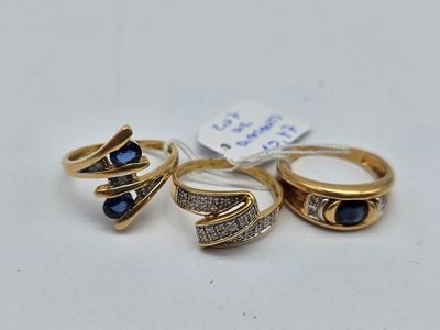 three gold rings with sapphire stones and diamonds