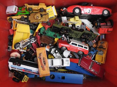 un bac rouge rempli de petites voitures et de petits camions