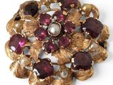 an image of a close up of a brooch with pearls and garnets
