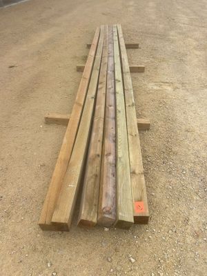 un long banc en bois posé au milieu d'un chemin de terre