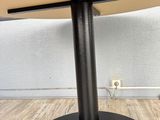 a close up of a table with a metal base and a wooden table top