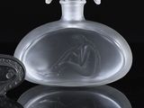 a glass bottle with a horse on it on a black surface
