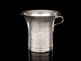 pichet en verre plaqué argent posé sur une surface noire avec reflet