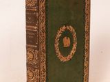 un vieux livre posé sur une table blanche à côté d'un mur blanc