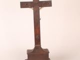 an old wooden cross on a stand against a white background