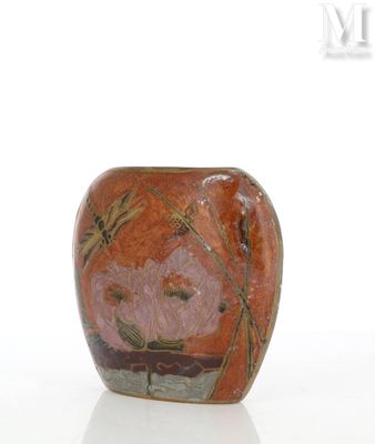un vase orné d'un motif floral sur une surface blanche