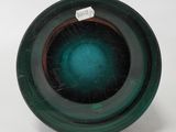 a close up of a green glass object on a white surface