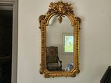 un miroir accroché au mur au-dessus d'une chaise