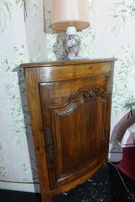 un petit meuble en bois surmonté d'une lampe