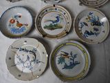 many plates that have birds on them on a table