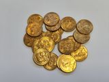 a pile of gold coins sitting on top of a white surface
