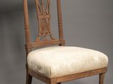 une chaise ancienne en bois avec une assise rembourrée beige