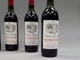 four bottles of wine are lined up on a white surface