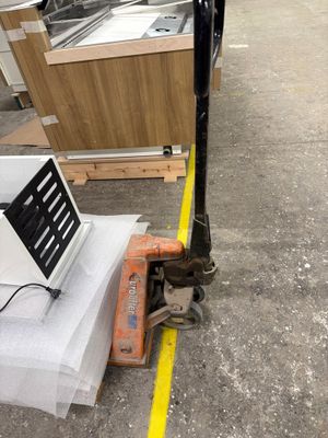 un ordinateur portable posé sur une palette dans un entrepôt