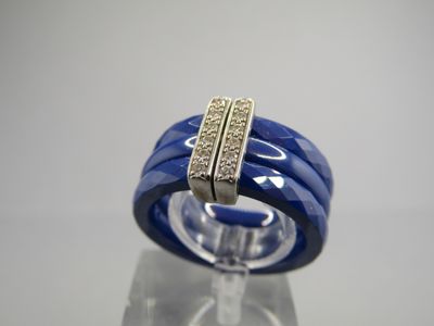 an image of a blue ring with diamonds on a clear surface