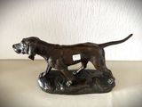 une statue représentant un chien debout sur un rocher