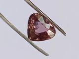 un gros plan sur un diamant rose en forme de cœur monté sur un crochet en argent