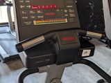two tread machines in the gym with people in the background