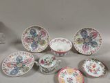 many plates and cups sitting on a table with papers