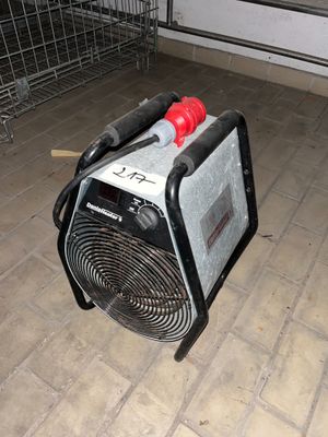 un petit ventilateur posé par terre à côté d'un support métallique