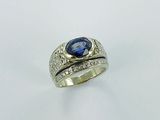 a close up of a ring with a blue stone and diamonds